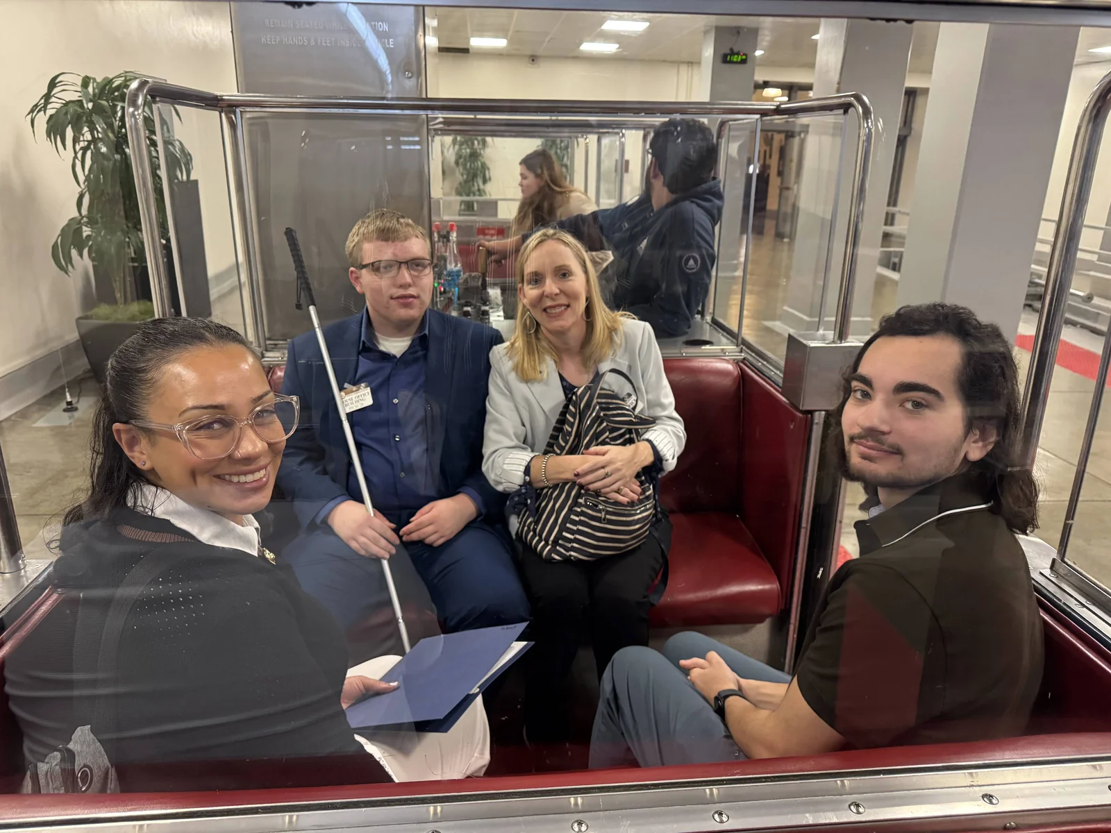 Four members of the group sit together in a Capitol subway car.