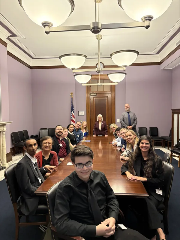 The group sits around a long conference table, with Rob nearest the camera.
