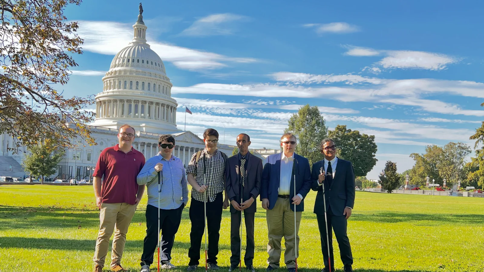 Six members of the group pose together on the Capitol lawn.