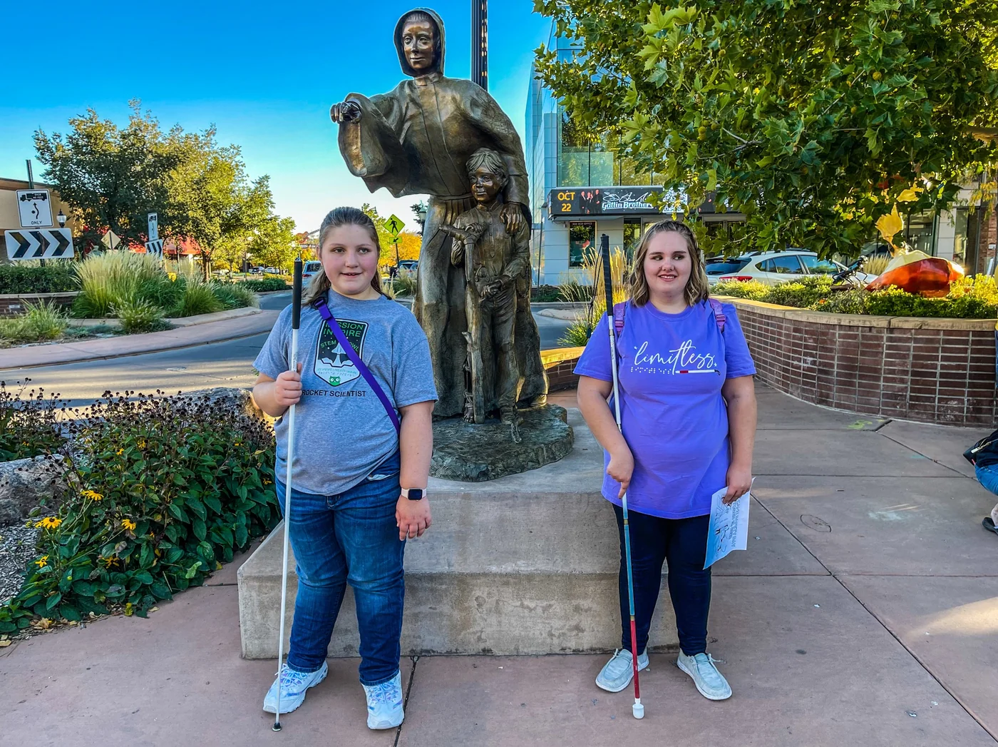 Isabelle and Hayden stand with their white canes in front of the Sister Mary Balbina Farrell statue at 7th and Main in downtown Grand Junction.